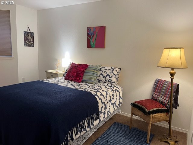 5130 Southwest Multnomah Boulevard, Unit B Portland, OR 97219 - Photo 7 of 36 a bedroom with a bed and a lamp on table