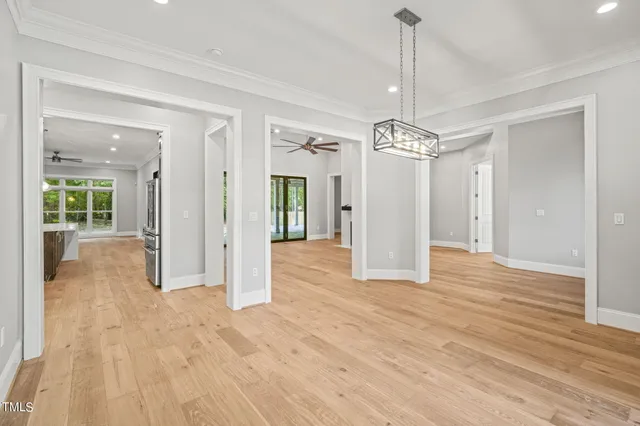 a view of a hallway with wooden floor and a chandelier