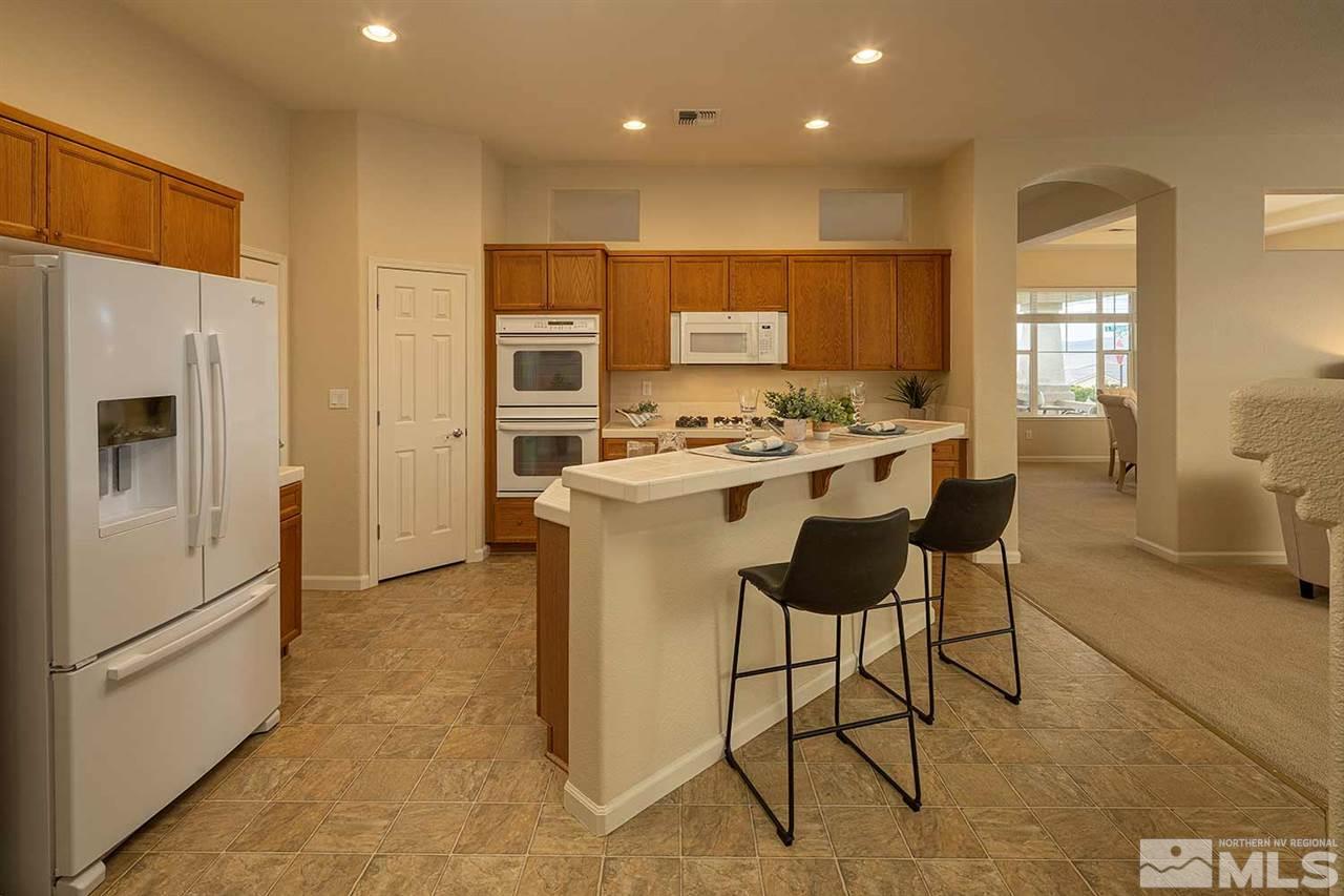 2201 South Tesuque Road Reno, NV 89511 - Photo 11 of 40 a kitchen with stainless steel appliances a stove a refrigerator sink and cabinets