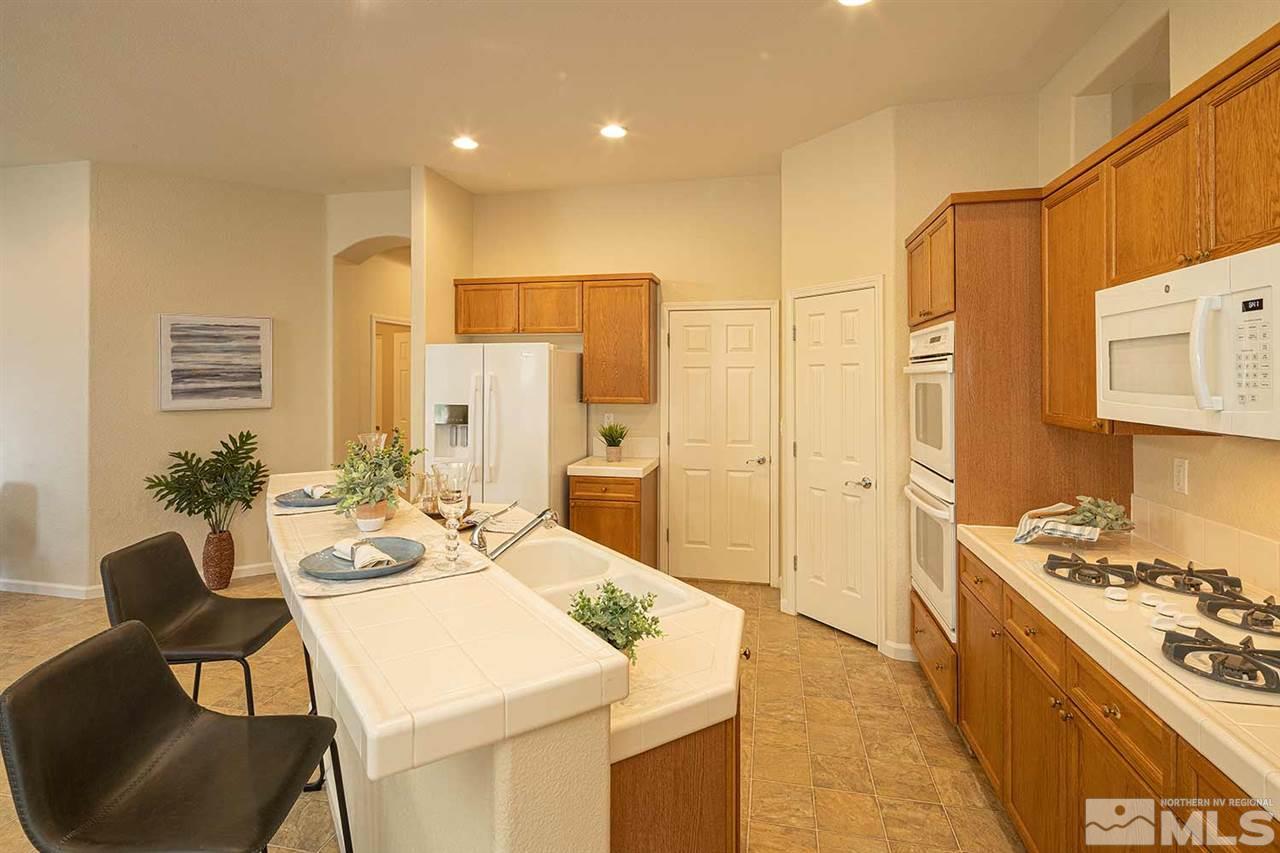 2201 South Tesuque Road Reno, NV 89511 - Photo 12 of 40 a large kitchen with sink a refrigerator and chairs
