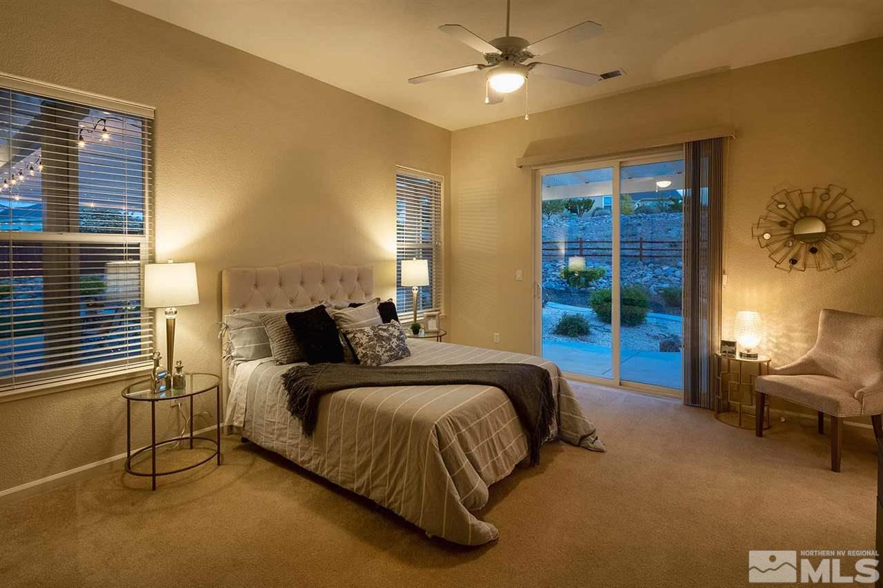 2201 South Tesuque Road Reno, NV 89511 - Photo 21 of 40 a spacious bedroom with a bed and a chandelier