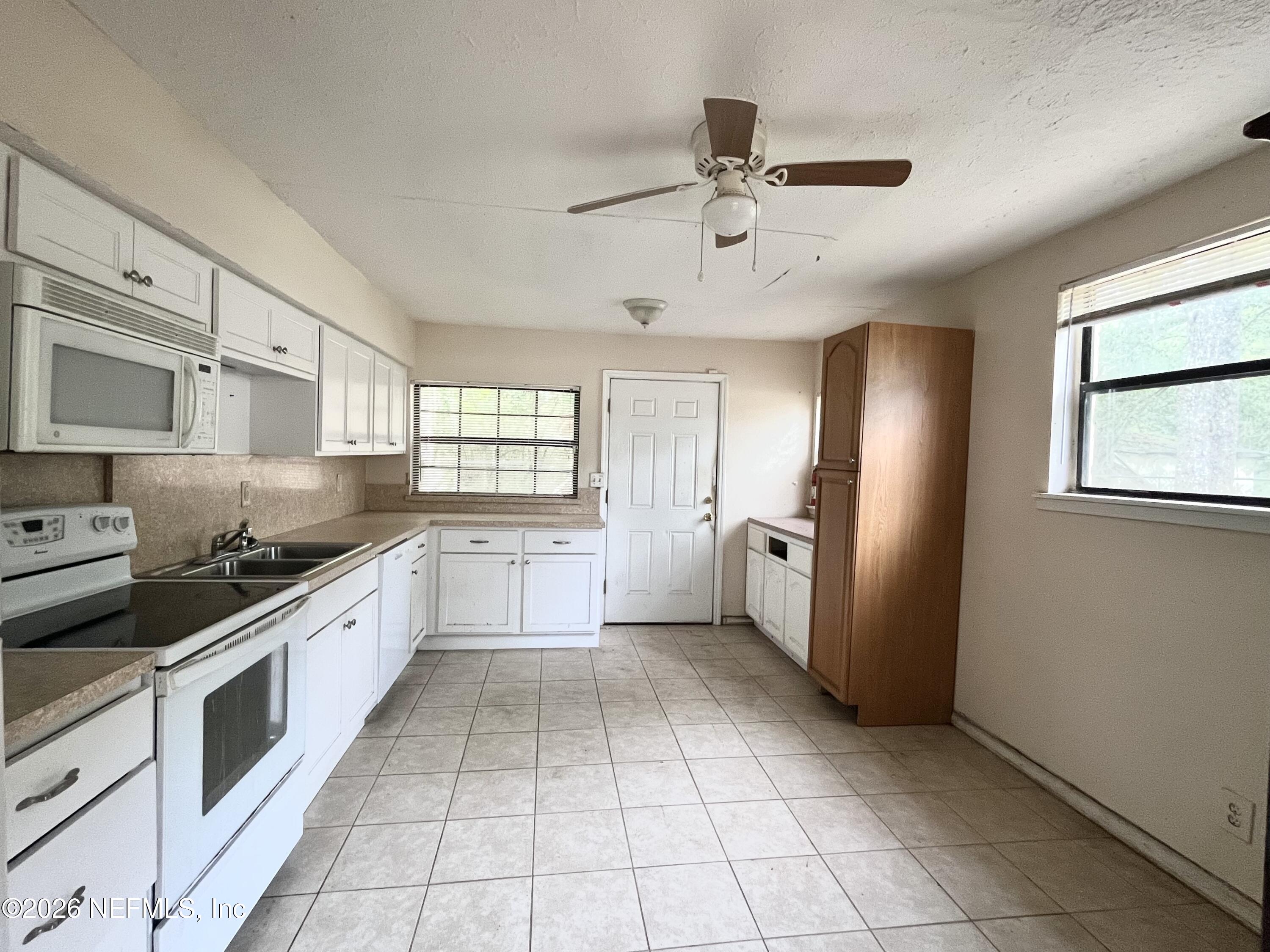 9926 Frankella Road Jacksonville, FL 32208 - Photo 11 of 18 a large kitchen with cabinets and stainless steel appliances