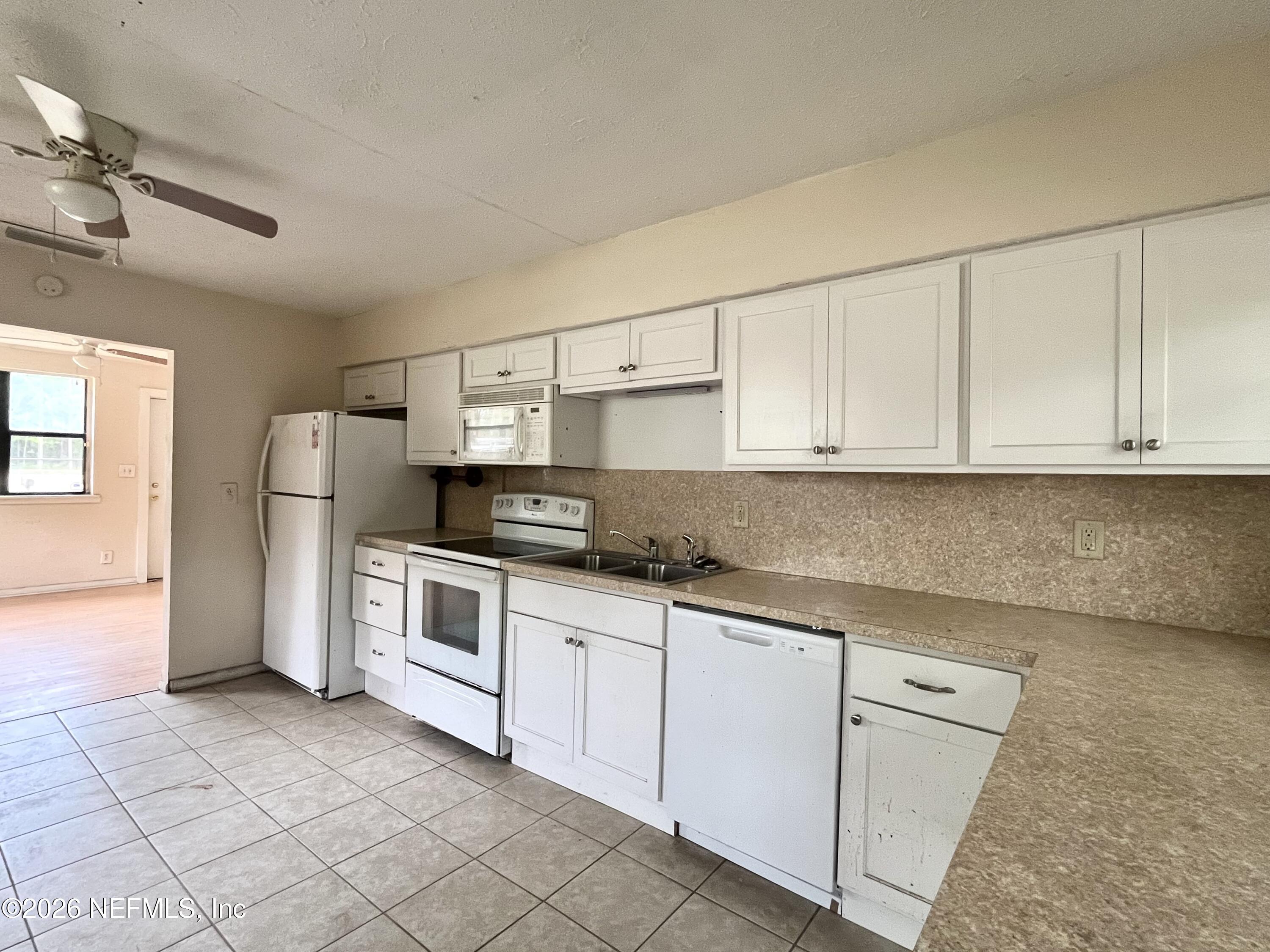 9926 Frankella Road Jacksonville, FL 32208 - Photo 12 of 18 a kitchen with white cabinets and white appliances