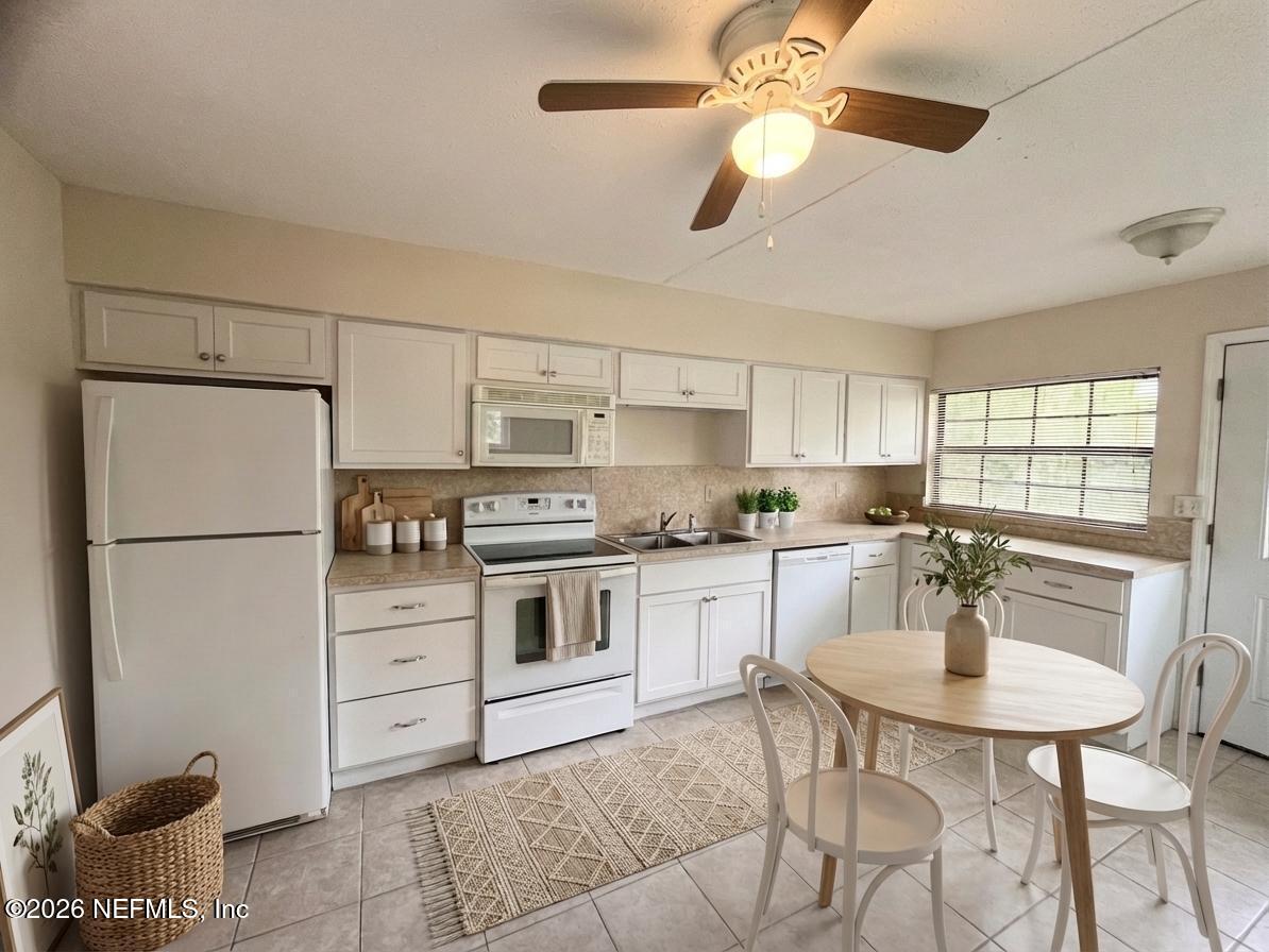9926 Frankella Road Jacksonville, FL 32208 - Photo 5 of 18 a kitchen with stainless steel appliances kitchen island granite countertop a table chairs and a refrigerator