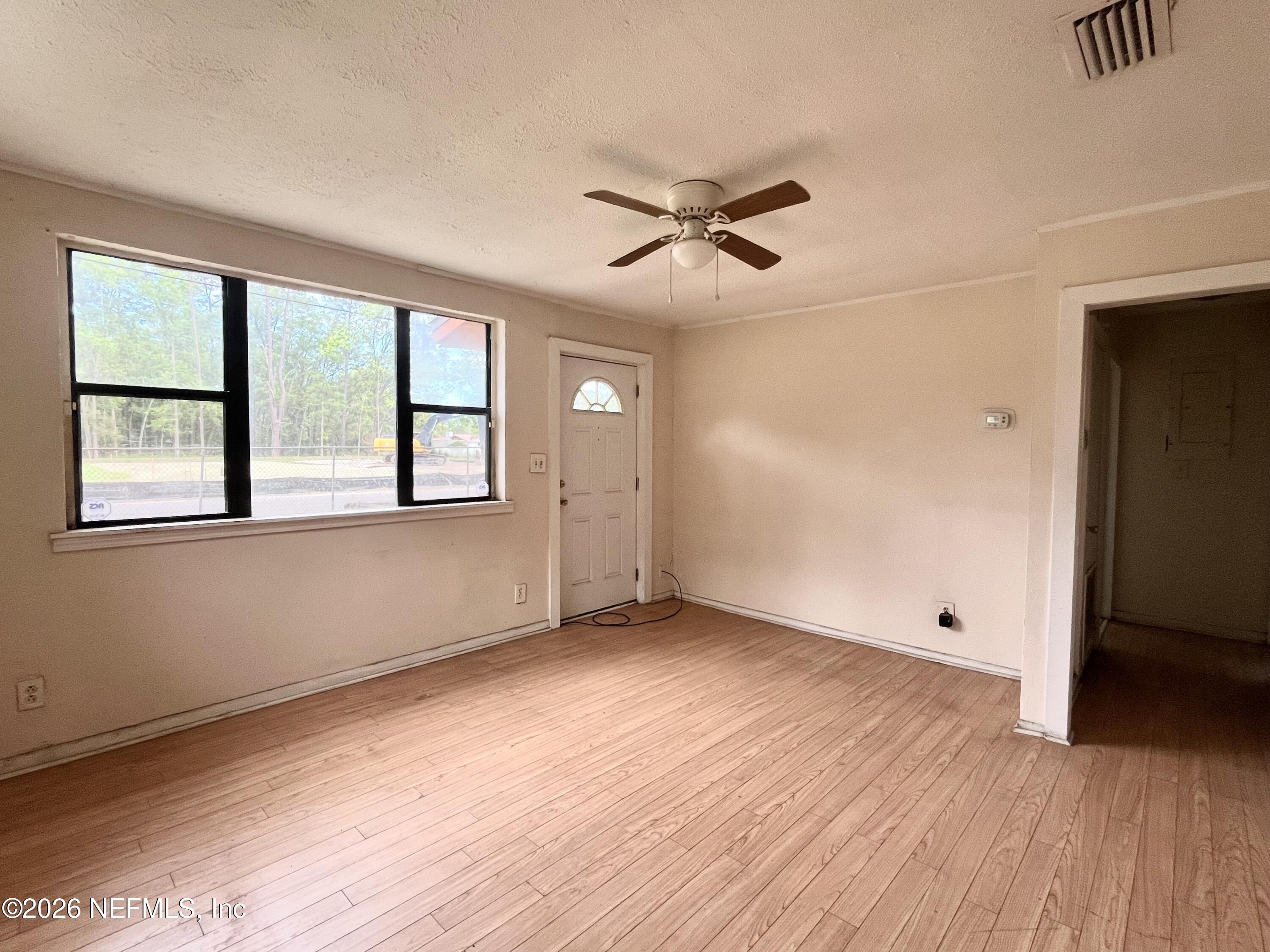 9926 Frankella Road Jacksonville, FL 32208 - Photo 7 of 18 a view of empty room with wooden floor and fan