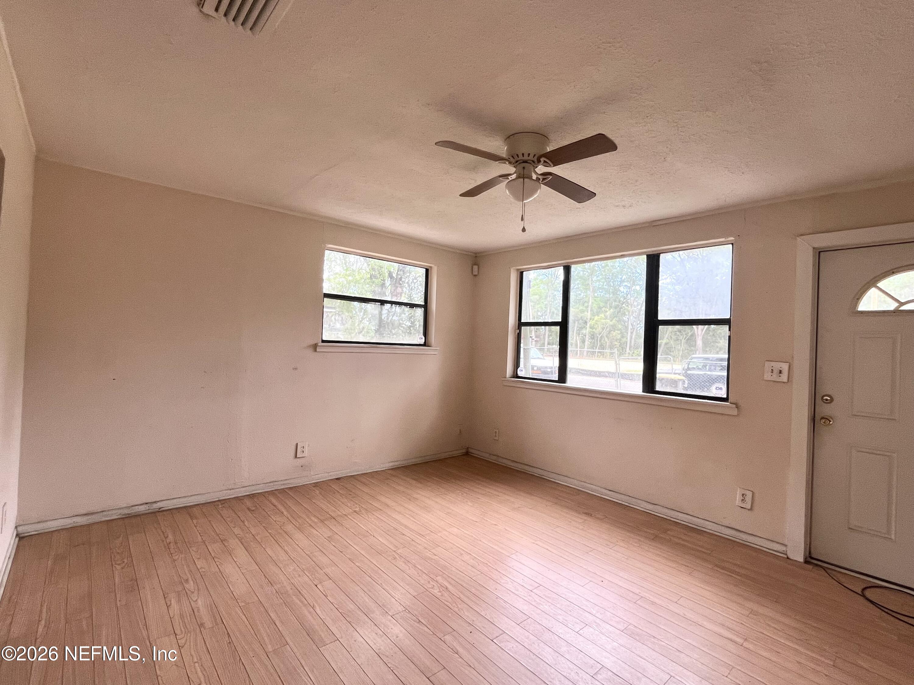 9926 Frankella Road Jacksonville, FL 32208 - Photo 8 of 18 a view of empty room with wooden floor and fan