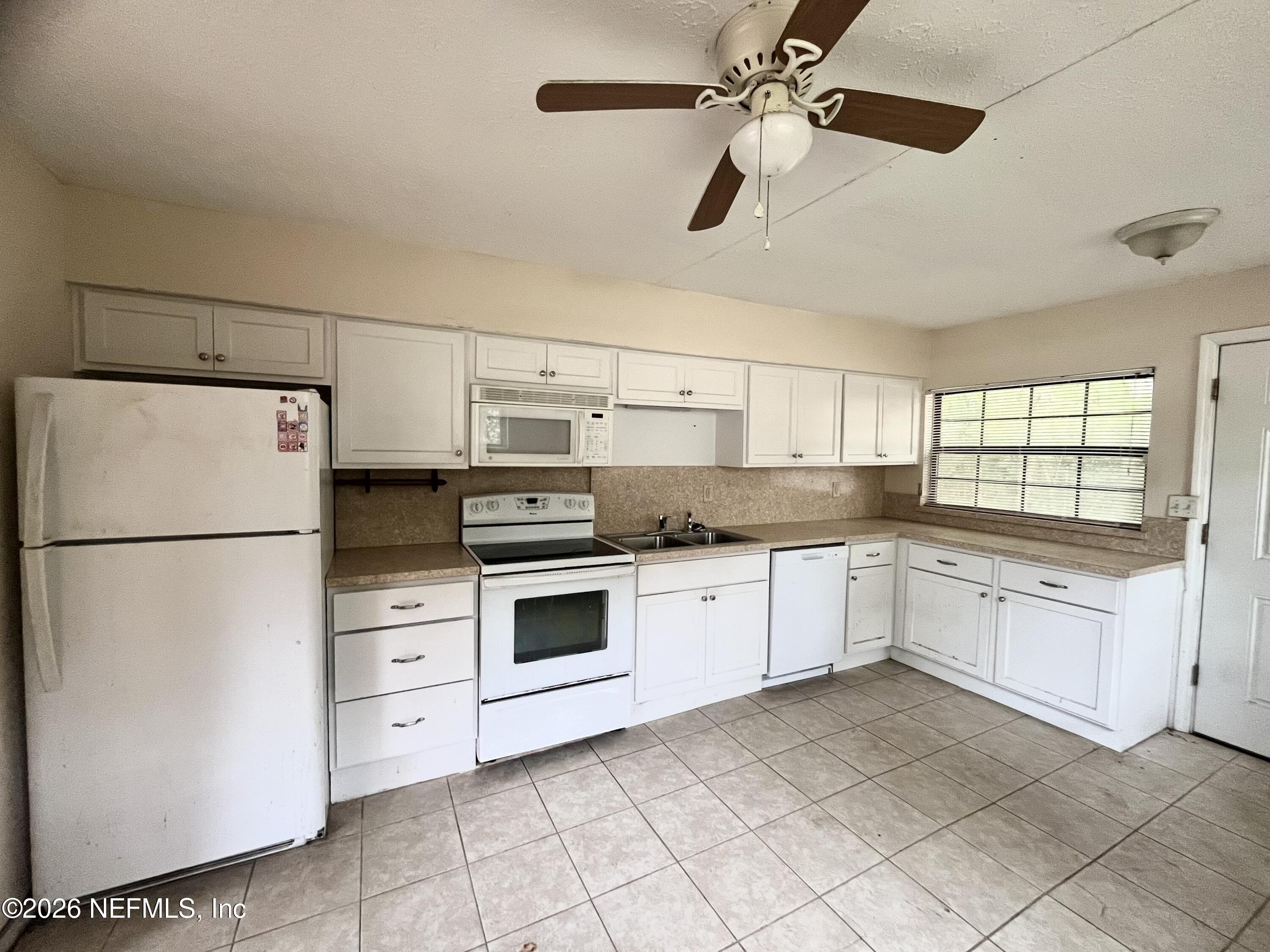 9926 Frankella Road Jacksonville, FL 32208 - Photo 10 of 18 a kitchen with granite countertop cabinets and white appliances