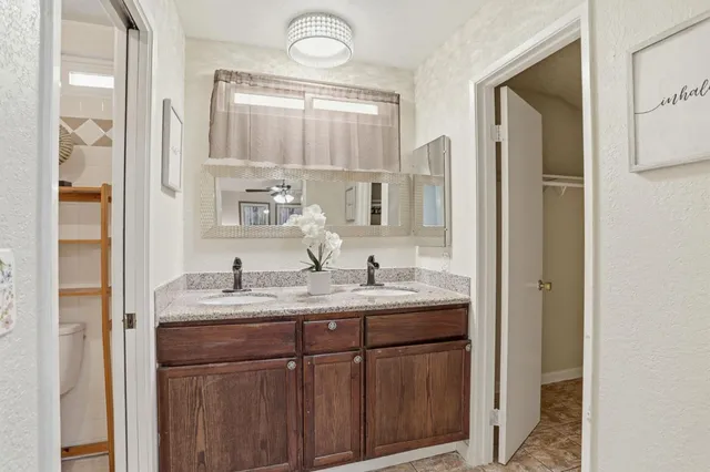 a bathroom with a granite countertop sink toilet and shower