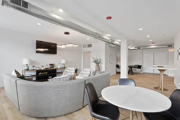 a living room with furniture a flat screen tv and kitchen view