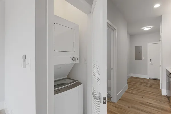 a view of a hallway with wooden floor and closet area