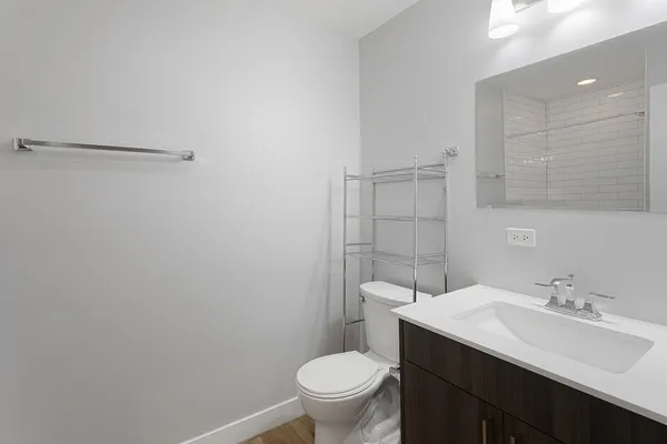 a bathroom with a sink a toilet and a mirror