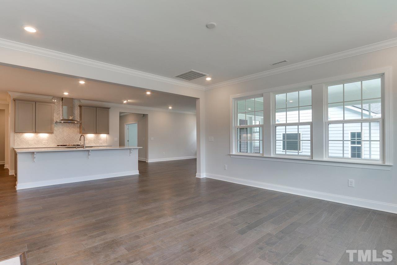 244 Ivory Lane, Unit 72 Raleigh, NC 27610 - Photo 10 of 30 a view of an empty room with wooden floor and a kitchen