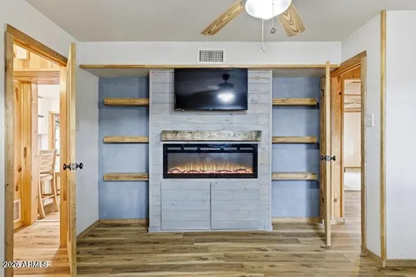 a view of a livingroom with wooden floor and a flat screen tv