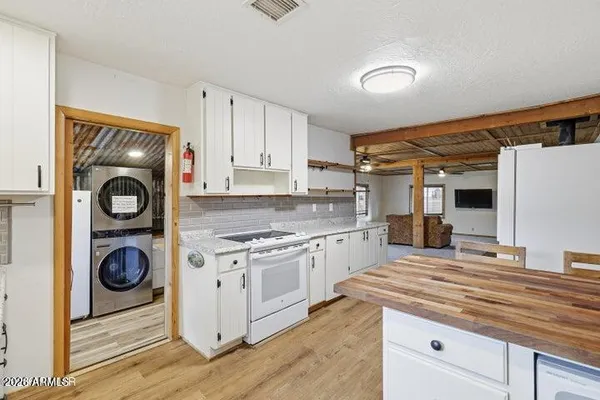 a kitchen with a stove and a white wooden cabinets