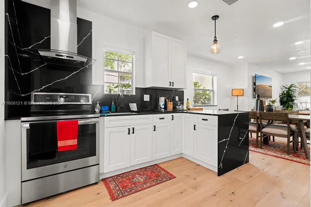 a kitchen with stainless steel appliances kitchen island granite countertop a stove a sink and a microwave