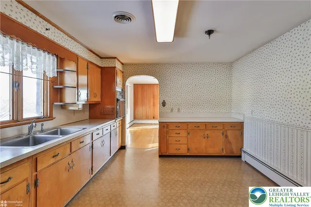 a large kitchen with stainless steel appliances granite countertop a large window