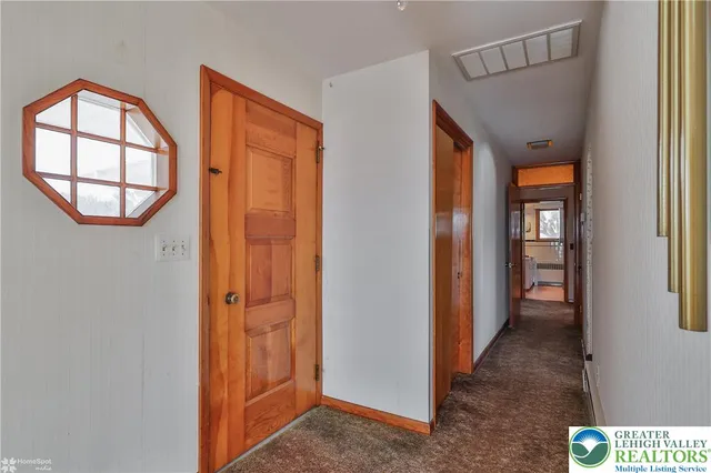 a view of a hallway with wooden floor and windows