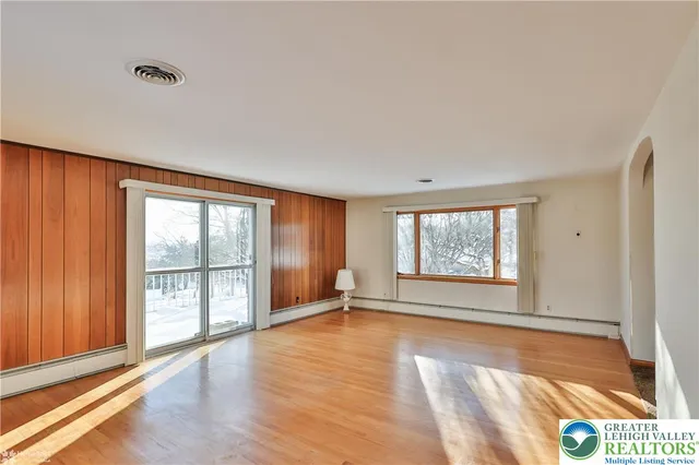 an empty room with windows and closet