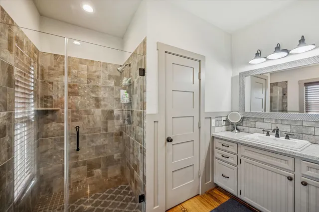a bathroom with a double vanity sink mirror and shower