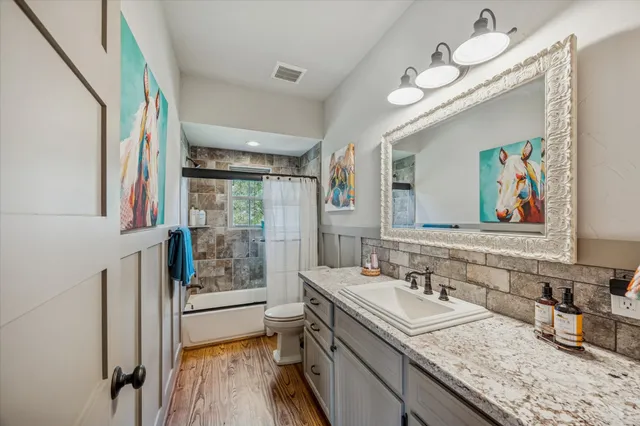 a bathroom with a granite countertop sink mirror and window