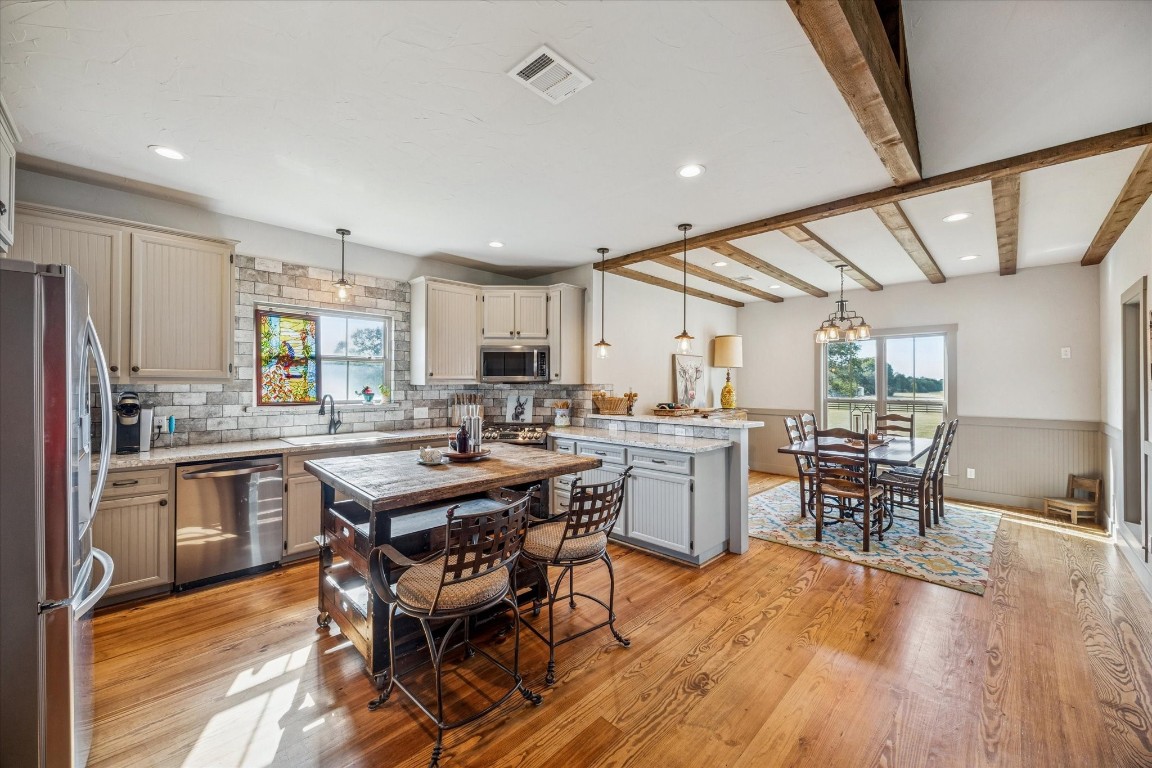 13792 Farm To Market Road 1094 Cat Spring, TX 78933 - Photo 9 of 25 a kitchen with a table chairs wooden floors and stainless steel appliances