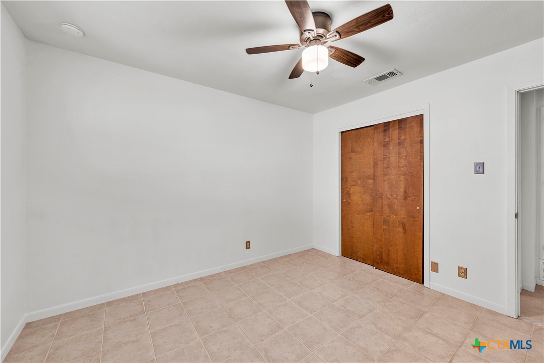 313 Ruggles Loop Temple, TX 76501 - Photo 14 of 22 an empty room with a chandelier fan and windows