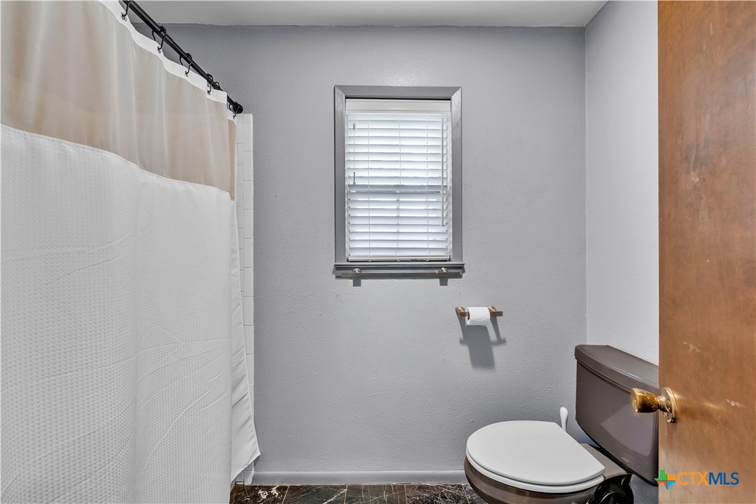 313 Ruggles Loop Temple, TX 76501 - Photo 16 of 22 a white toilet sitting next to a bathroom sink