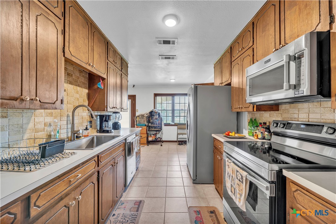 313 Ruggles Loop Temple, TX 76501 - Photo 8 of 22 a kitchen with stainless steel appliances granite countertop a sink stove and refrigerator