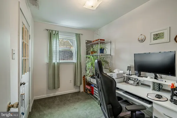 a view of a workspace with furniture and a window