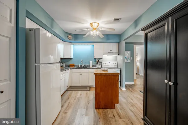 a kitchen with stainless steel appliances granite countertop a refrigerator a sink and a stove