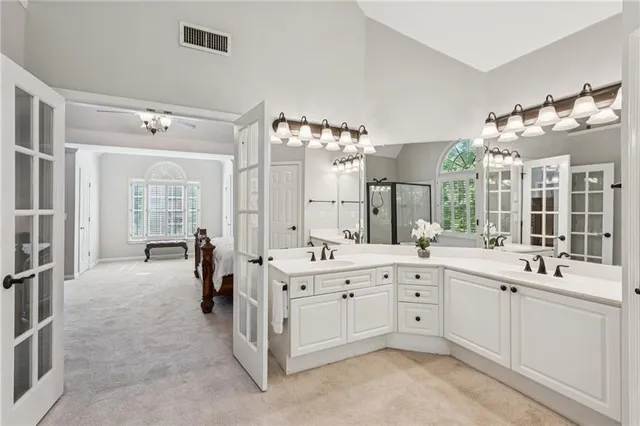 a large white kitchen with a sink and dishwasher with white cabinets