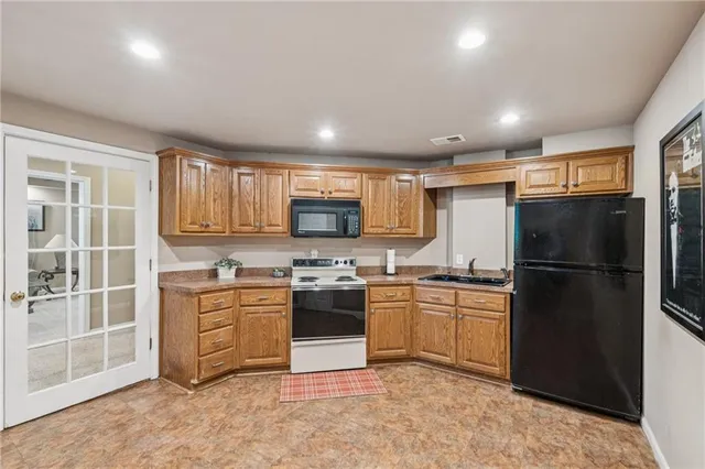 a kitchen with stainless steel appliances granite countertop a refrigerator stove top oven and sink