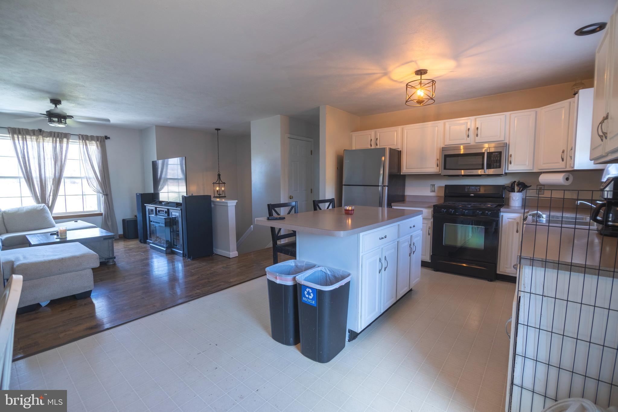 185 Elfner Road Red Lion, PA 17356 - Photo 18 of 34 a large kitchen with stainless steel appliances granite countertop a stove a sink dishwasher a dining table and chairs with wooden floor