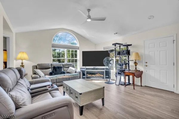 a living room with furniture a window and a flat screen tv