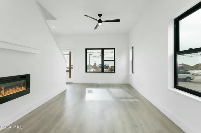 a view of an empty room with a window and fireplace
