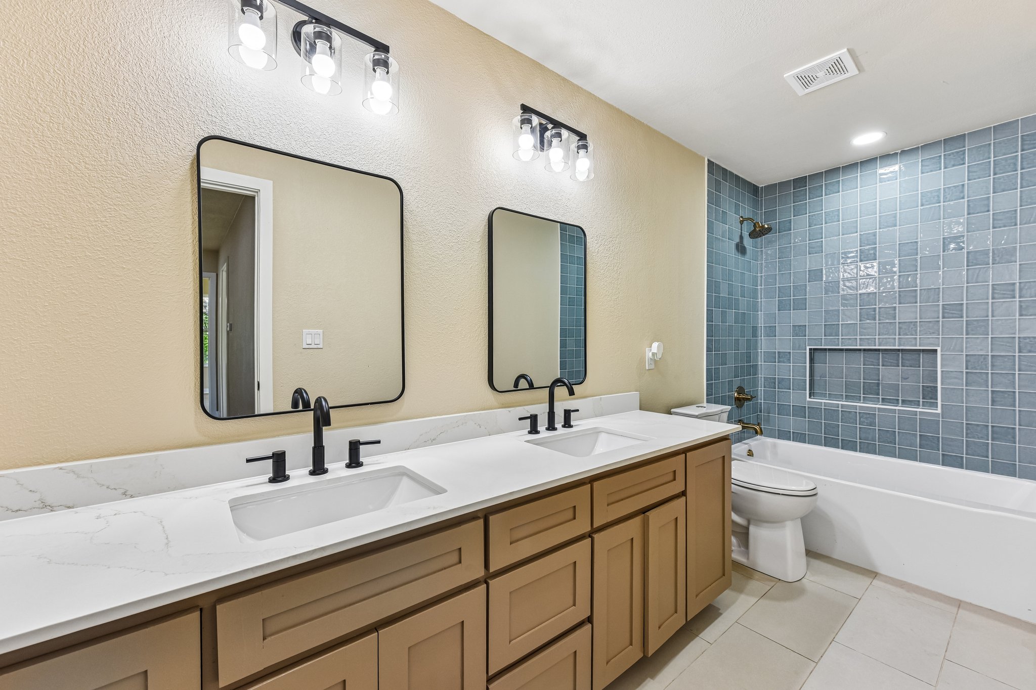 7523 Glenhill Road Austin, TX 78752 - Photo 25 of 38 Double vanities and modern tilework elevate this well-appointed bathroom.