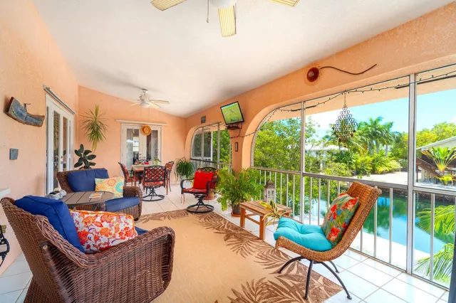 a living room with patio furniture and a large window