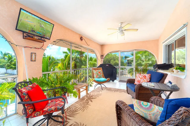 a outdoor living space with furniture a flat screen tv and a floor to ceiling window