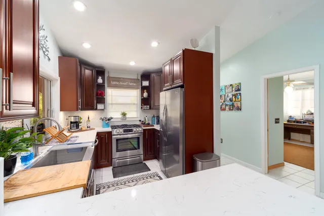 a kitchen with stainless steel appliances kitchen island granite countertop a refrigerator stove and sink