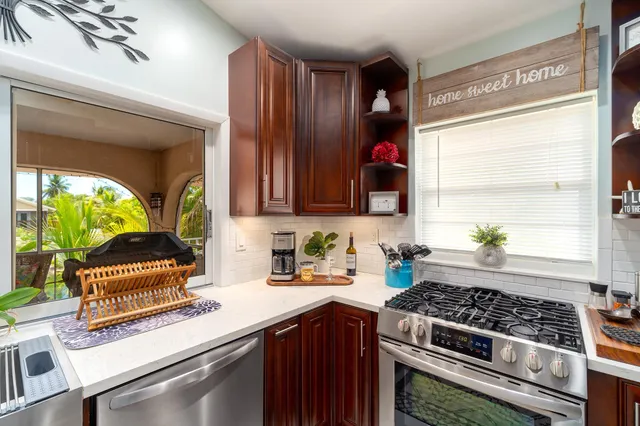 a kitchen with stainless steel appliances a sink stove and window