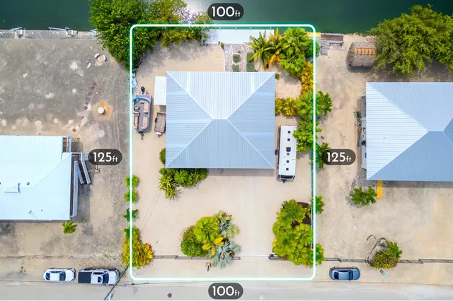 an aerial view of a house with a yard and a car park