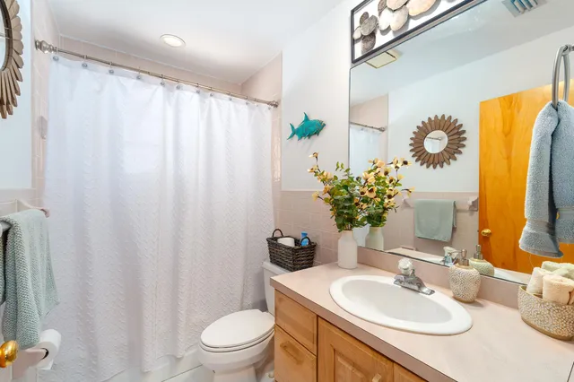 a bathroom with a granite countertop sink a toilet and a mirror