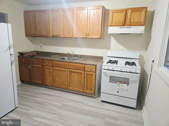 a kitchen with a stove sink and cabinets
