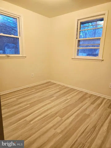 a view of a room with wooden floor and windows