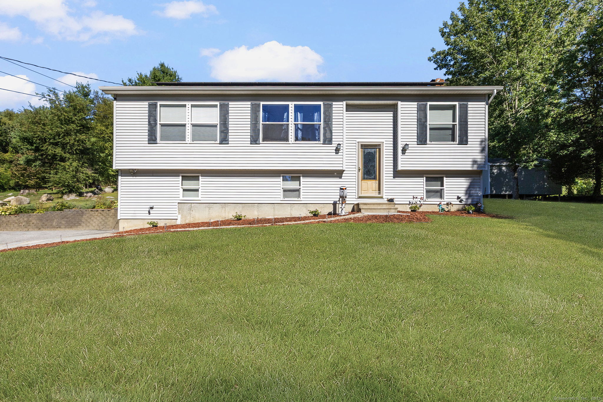 a front view of a house with a yard and trees