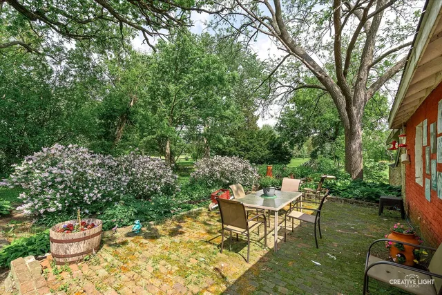 a backyard of a house with a fountain table and chairs