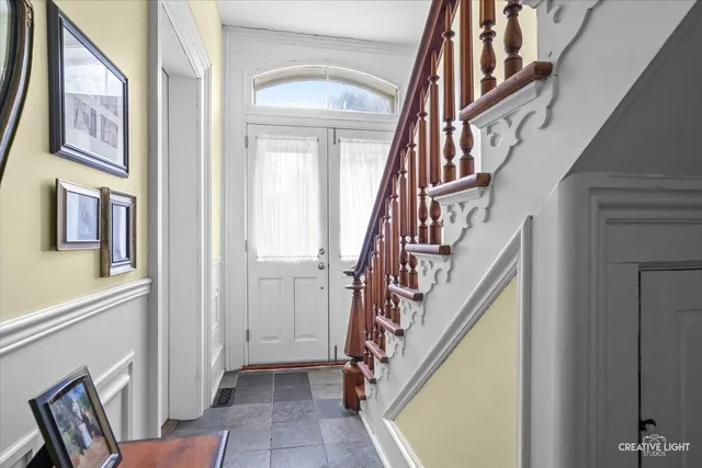a view of an entryway with lots of frames and paintings on the wall