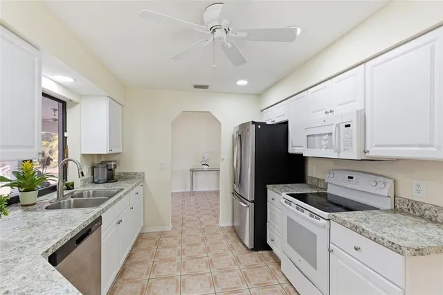 a open kitchen with stainless steel appliances granite countertop a sink stove and refrigerator
