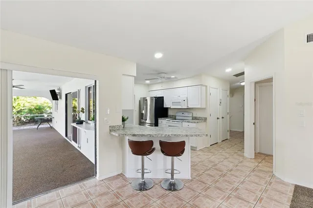 a large kitchen with kitchen island granite countertop a table and chairs