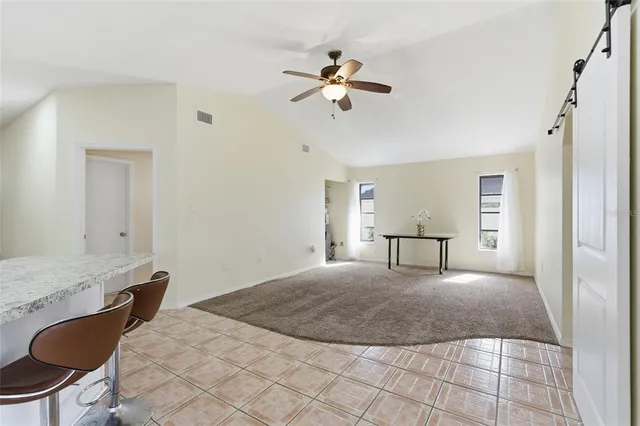 a view of a livingroom with a dinning area hardwood floor and a ceiling fan